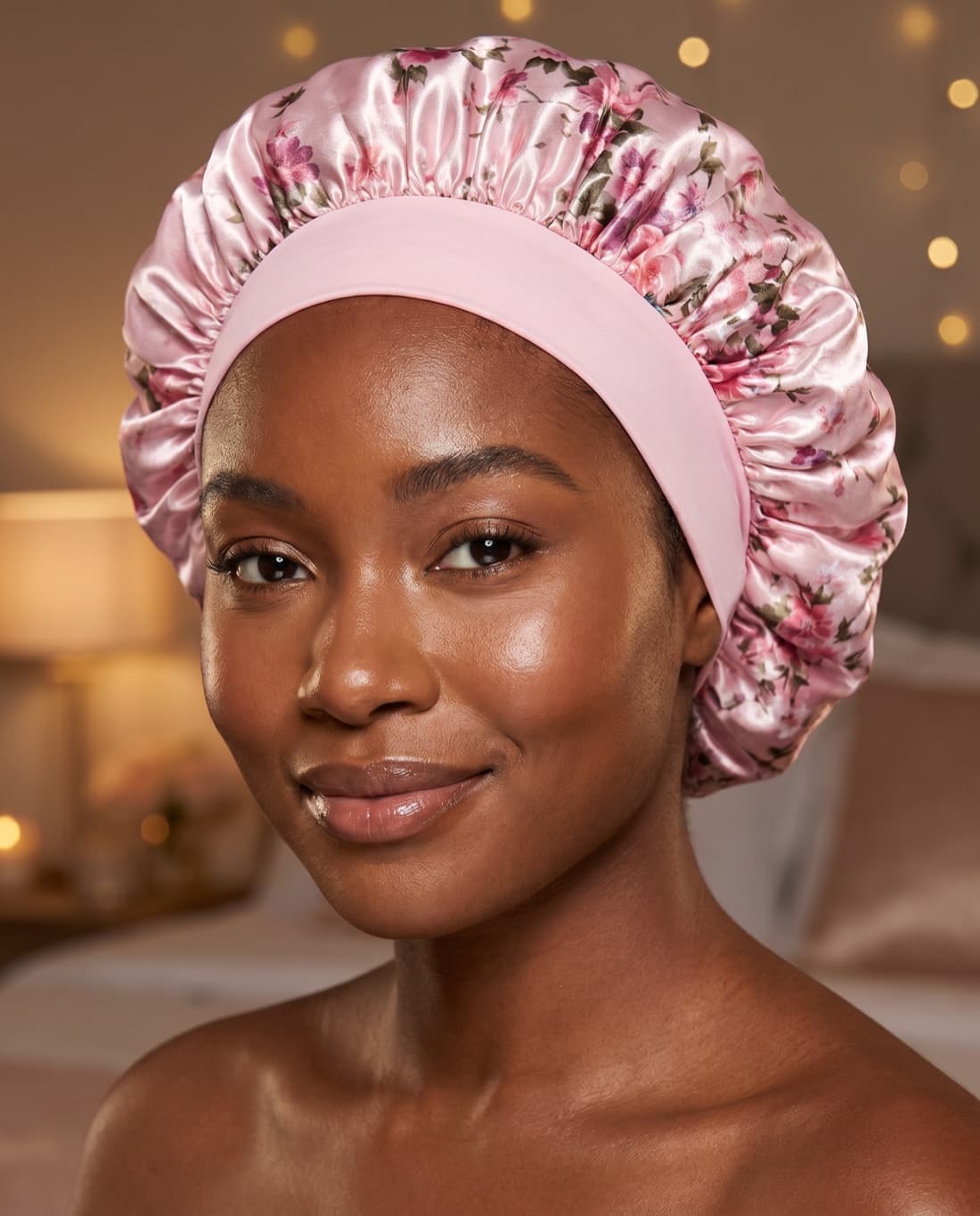 Woman wearing a light pink satin bonnet for bed